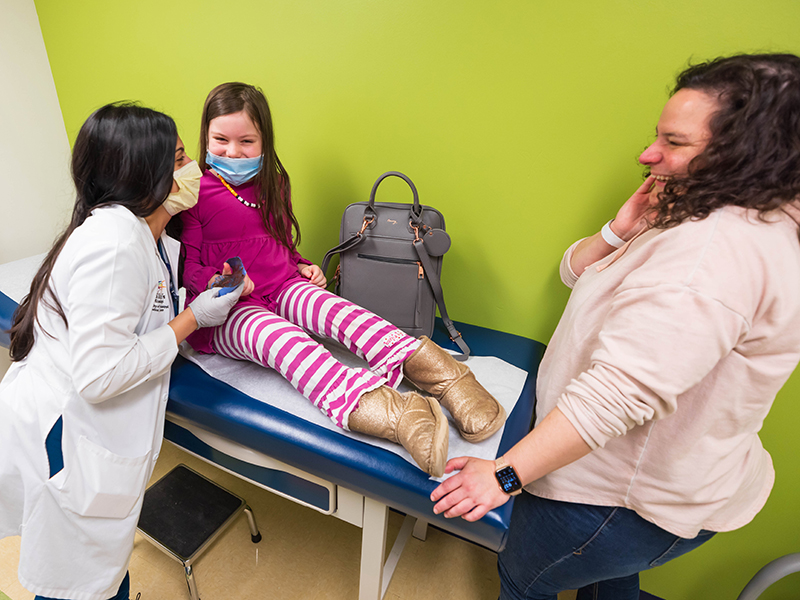 Dr. Natalie Bhesania gets a surprise: artwork by patient Stella Bowman of Mendenhall. Looking on is mom Hilary Bowman.